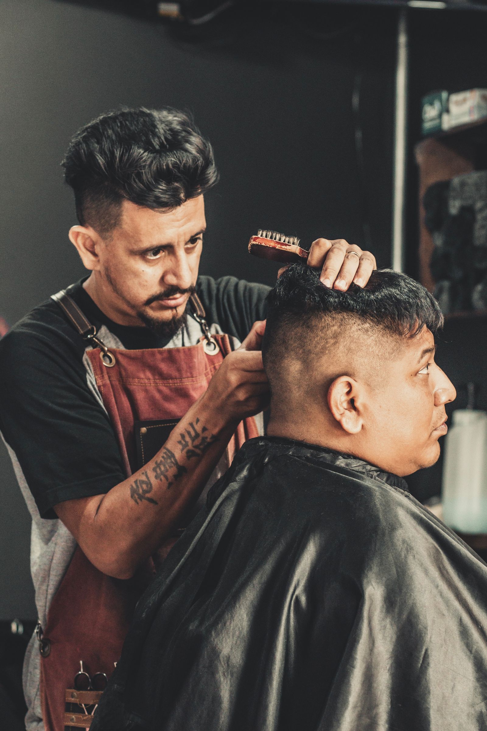 Een barber van Sharp Cuts werkt een fade af